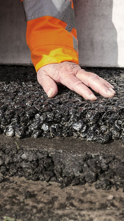 Een hand op het asfalt.