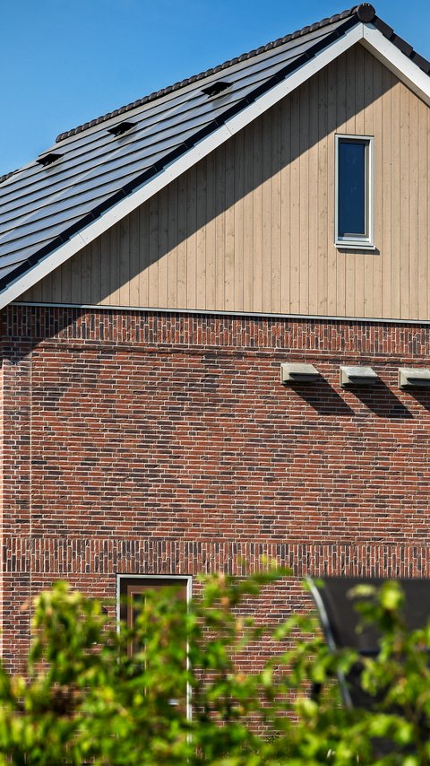 Bouw van de 16 horizon-woningen in Nuenen. Op de voorgrond zie je een plas.