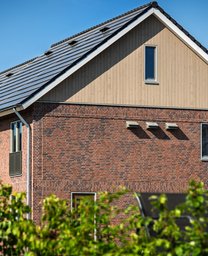 Bouw van de 16 horizon-woningen in Nuenen. Op de voorgrond zie je een plas.