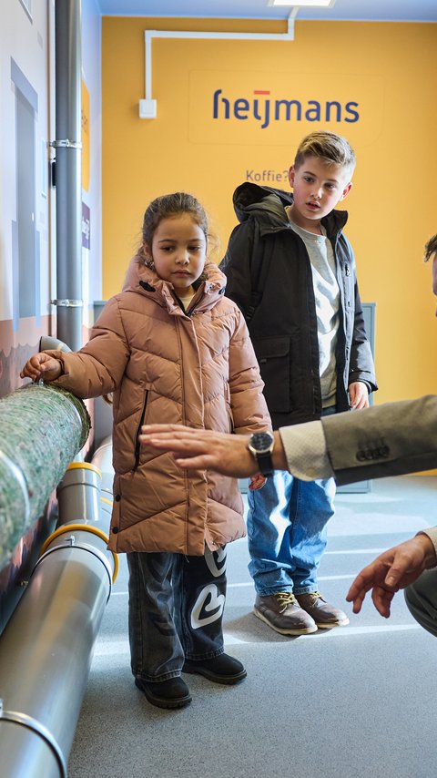 Regiodirecteur van Heijmans, Martein van der Veen, legt kinderen uit over water in de WaterWeetjesWagen.