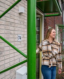 Bewoonster Inez van den Bos staat voor haar nieuwe woning in Eindhoven.