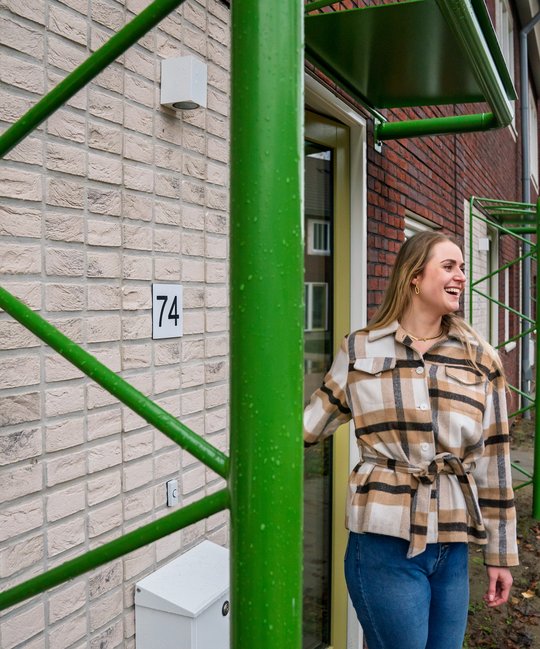 Bewoonster Inez van den Bos staat voor haar nieuwe woning in Eindhoven.