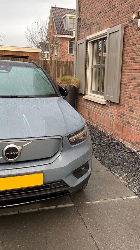 Elektrische auto die thuis wordt opgeladen aan een laadpaal voor een moderne woning.