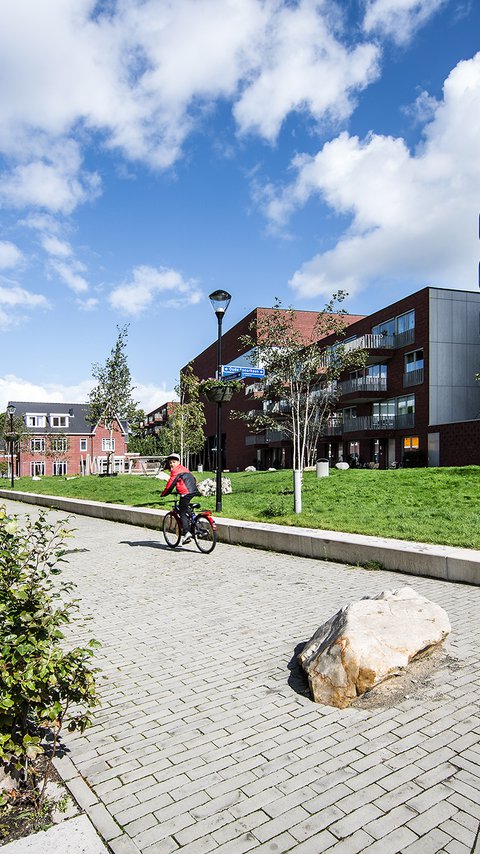 Straat in de wijk Villa Industria in Hilversum, gebouwd door Heijmans. Een fietser op de fiets.
