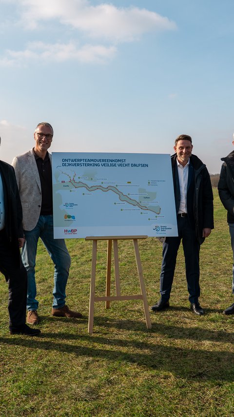 Vier mannen staan in een weiland naast de rivier de Vecht bij het ontwerp.