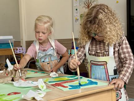 Kinderen met schort van bouwhekdoek gemaakt