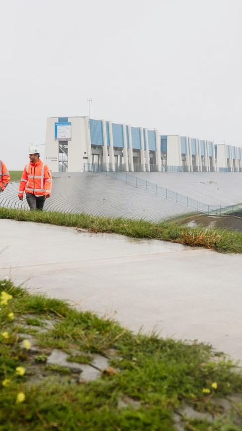 3 vakmensen lopen over de versterkte Lauwersmeerdijk